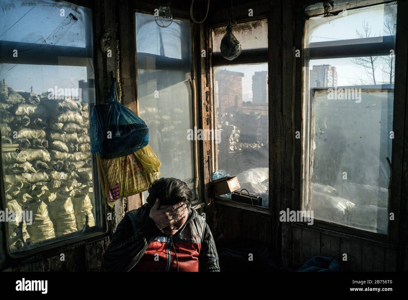 Un lavoratore durante una pausa. Lavora in un commercio di carbone e confeella sacchi di carbone per la vendita. [traduzione automatica] Foto Stock