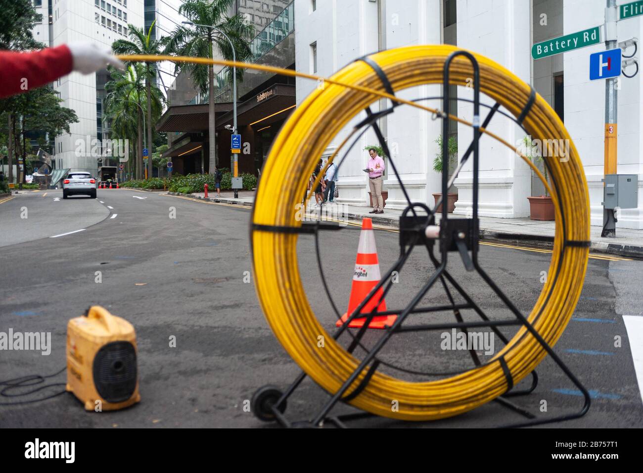 15.04.2018, Singapore, Repubblica di Singapore, Asia - un lavoratore posa cavi su una strada nel quartiere degli affari. [traduzione automatica] Foto Stock
