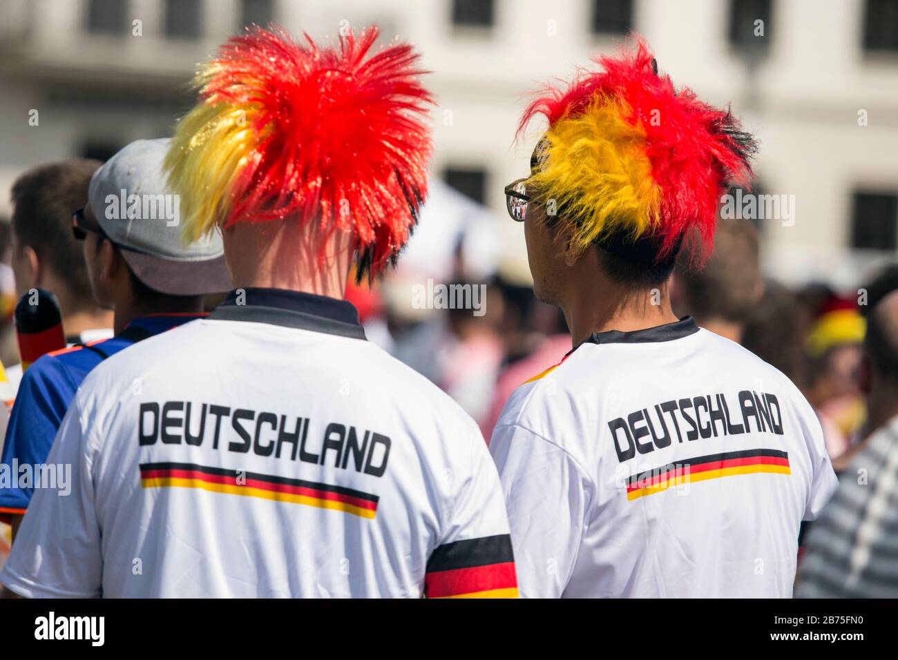 Gli appassionati di calcio tedeschi indosseranno divise peruviane nere e rosse e dorate e maglie tedesche per la partita di apertura tra Germania e Messico il 17 giugno 2018 alla porta di Brandeburgo nel Fan Mile di Berlino. [traduzione automatica] Foto Stock