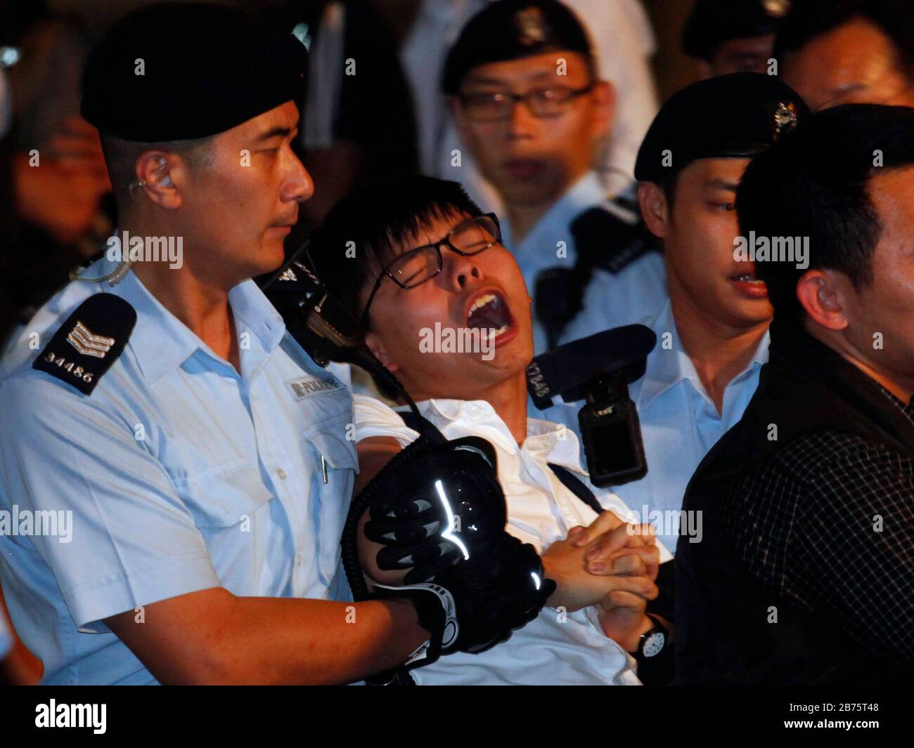 Joshua Wong del partito politico Demosisto arresto da parte della polizia dopo la sua protesta alla statua Golden Bauhinia a Hong Kong, Cina, 28 giugno 2017. La statua di Golden Bauhinia fu un regalo del governo cinese che celebrò il ritorno di Hong Kong nella Cina continentale nel 1997. La protesta si è svolta accanto al Centro Congressi, in vista della visita del Presidente cinese Xi Jinping, dove inaugurerà un nuovo Chief Executive di Hong Kong e per celebrare il ventesimo anniversario della consegna della città dal dominio britannico a quello cinese il 01 luglio. Foto Stock