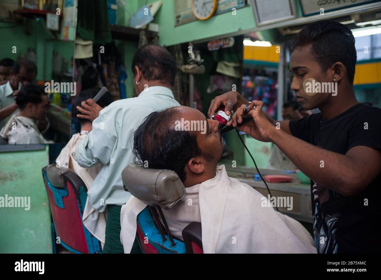 26.01.2017, Yangon, Repubblica dell'Unione di Myanmar, Asia - due barbieri tagliare i capelli dei clienti a Yangon [traduzione automatica] Foto Stock