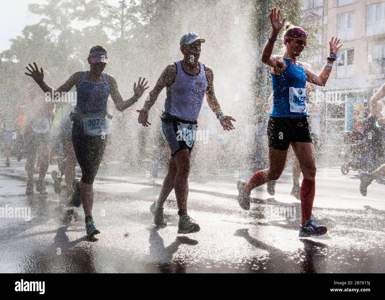 I partecipanti alla 43° Maratona di Berlino nel quartiere Schoeneberg di Berlino saranno rinfrescati con una doccia ad acqua. 41,283 corridori hanno partecipato alla maratona. [traduzione automatica] Foto Stock