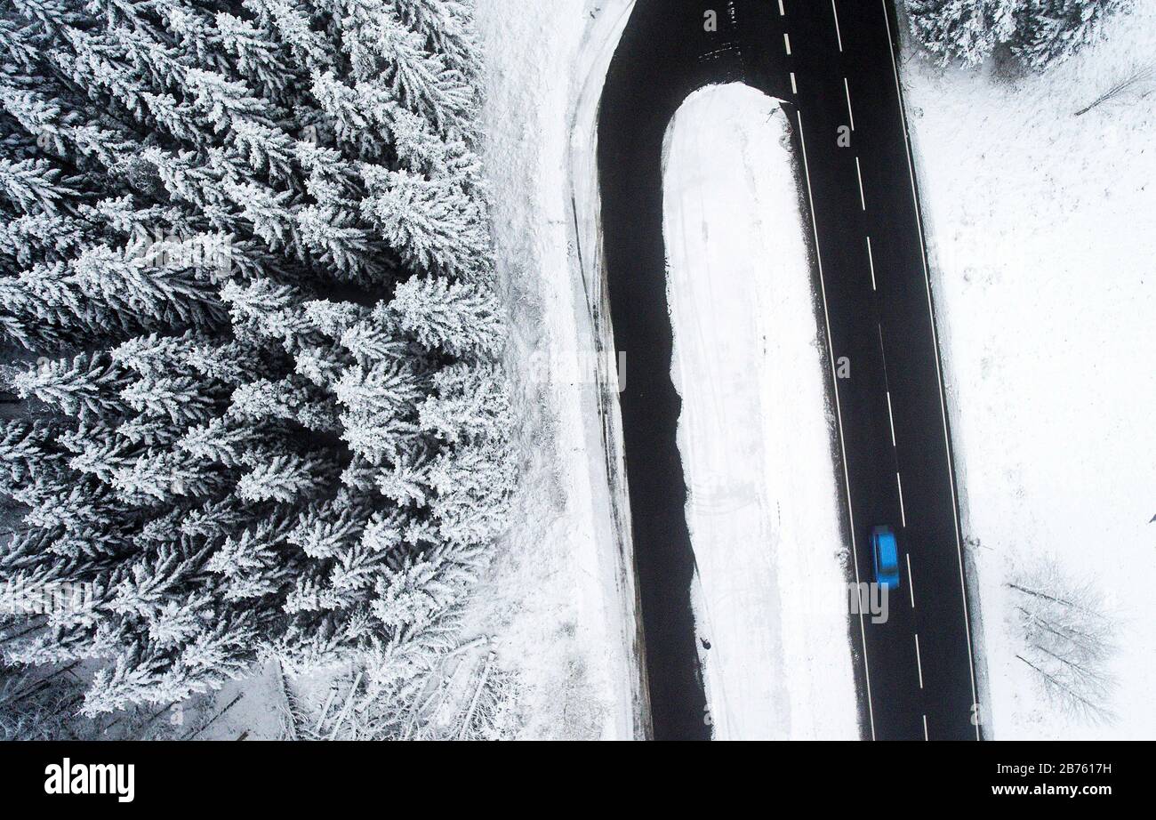 Una fotografia aerea mostra una macchina su una strada libera dalla neve in una foresta innevata nei monti Harz, il 09.11.2016. [traduzione automatica] Foto Stock