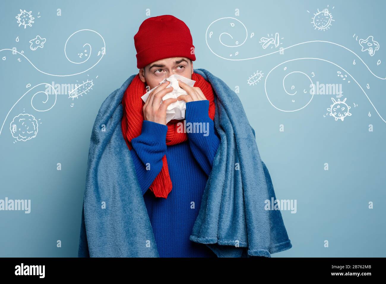 Ragazzo catturato un freddo e usa pillole per guarire. Studio su sfondo ciano Foto Stock