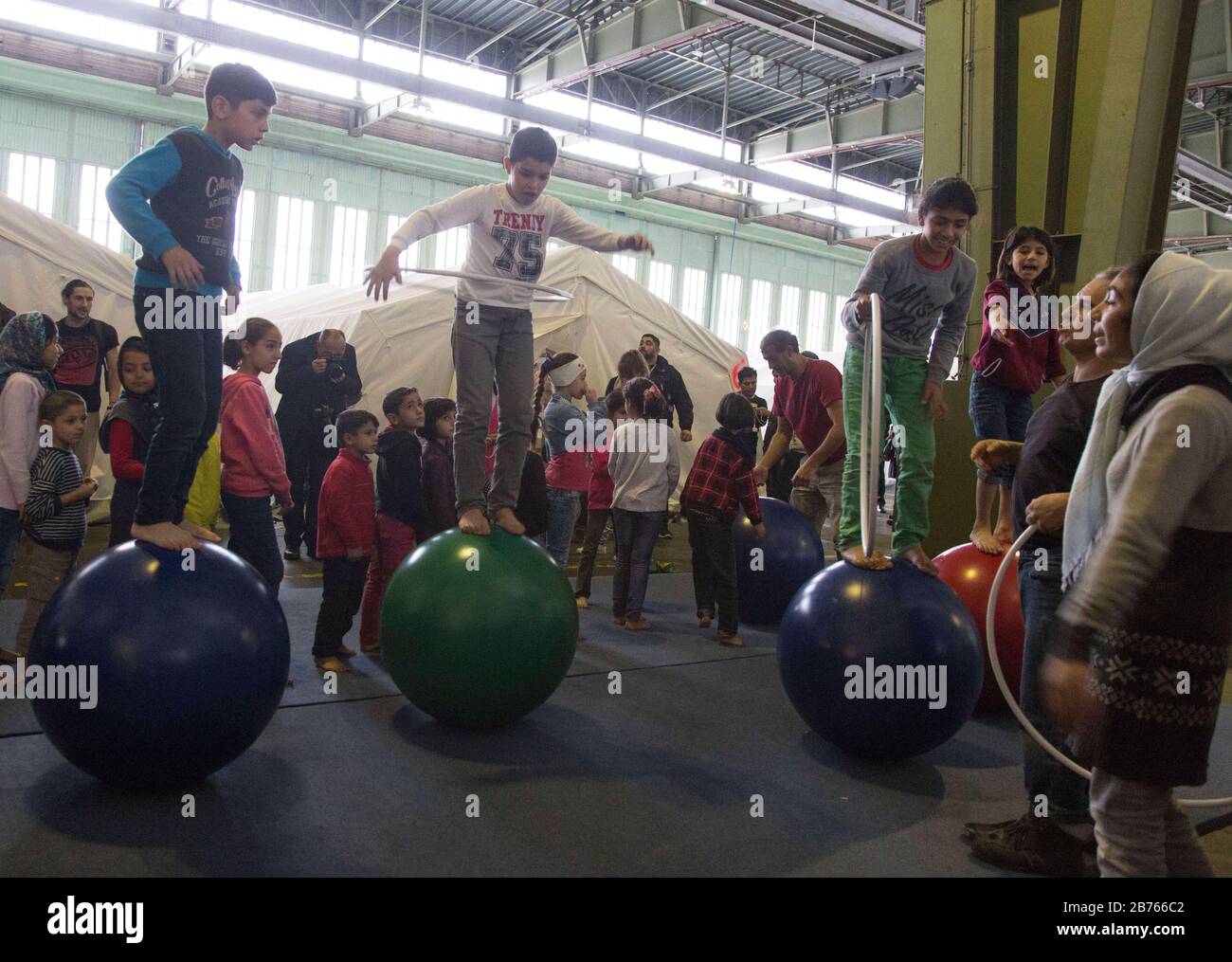 I bambini di rifugiati giocano tra le tende in un rifugio temporaneo per i rifugiati il 09.12.2015 nell'ex hangar dell'aeroporto di Tempelhof. L'aeroporto Tempelhof serve la città di Berlino come sistemazione d'emergenza per i rifugiati. [traduzione automatica] Foto Stock