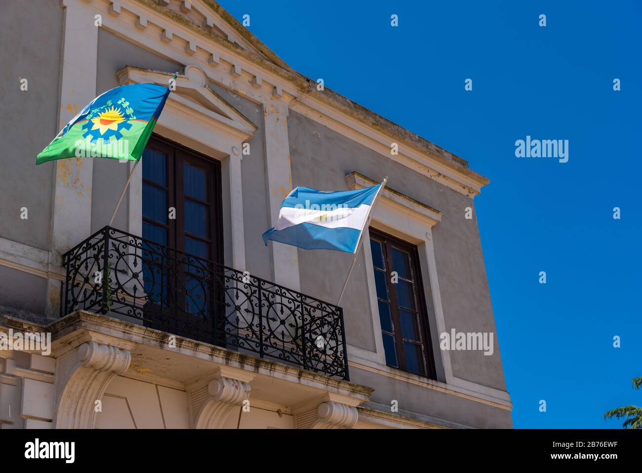 Provincia di Buenos Aires e bandiera di stato argentina fiammeggiante con uno sfondo blu cielo su un balcone Foto Stock
