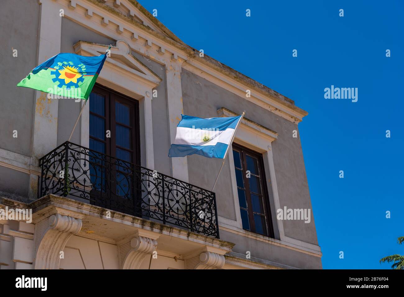 Provincia di Buenos Aires e bandiera di stato argentina fiammeggiante con uno sfondo blu cielo su un balcone Foto Stock