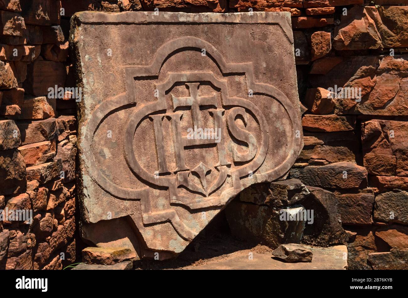 Pezzo di un pulpito di pietra scolpito o scolpito in pietra con il simbolo gesuita in rovine di San Ignacio, Misiones, Argentina Foto Stock