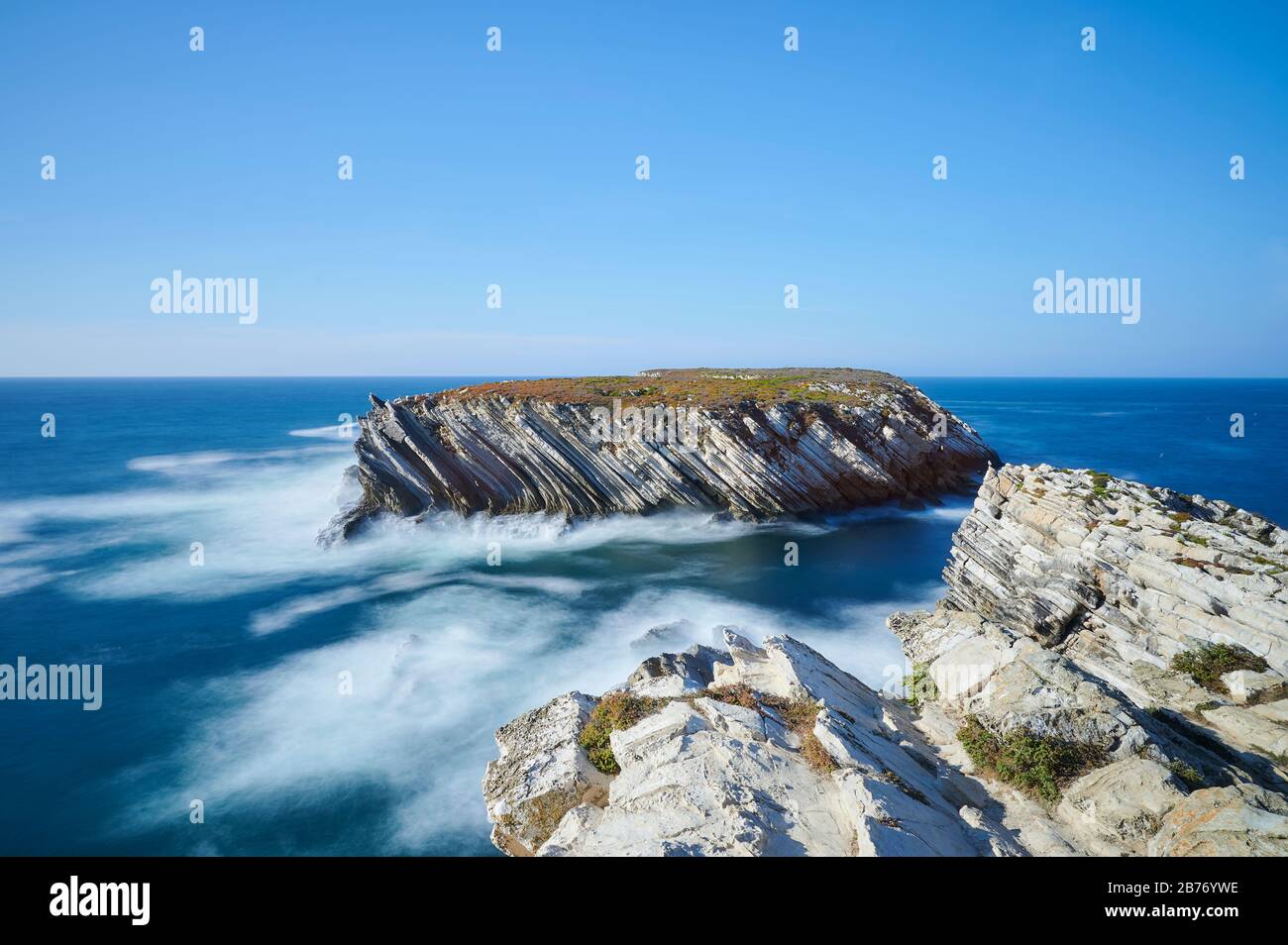 Piccola isola di roccia vicino alla riva lunga esposizione Foto Stock