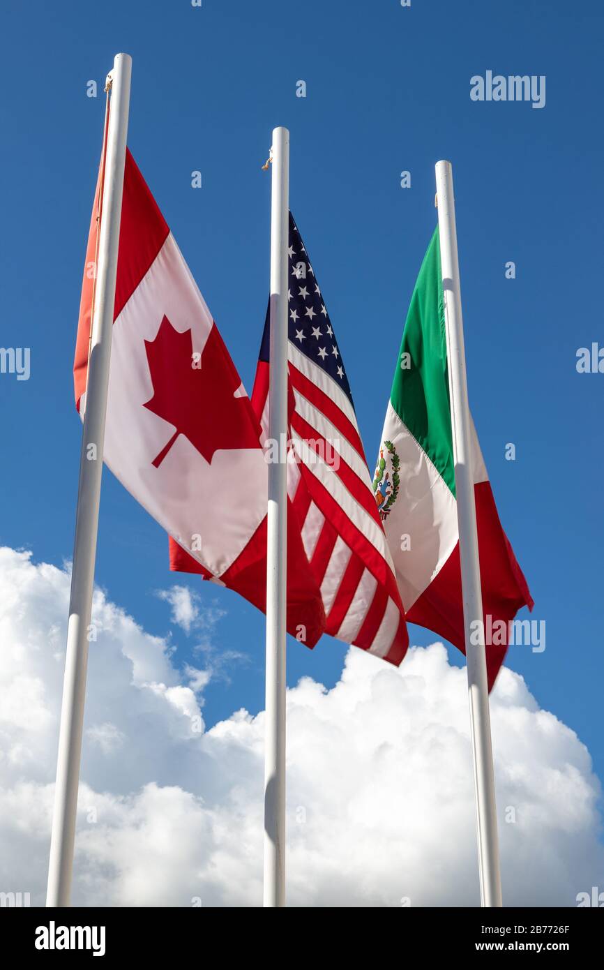 Bandiere di 3 paesi USMCA costituite da Stati Uniti, Messico, Canada sul palo di bandiera contro cielo, concetto di nuovo accordo NAFTA che è conosciuto come USMCA Foto Stock