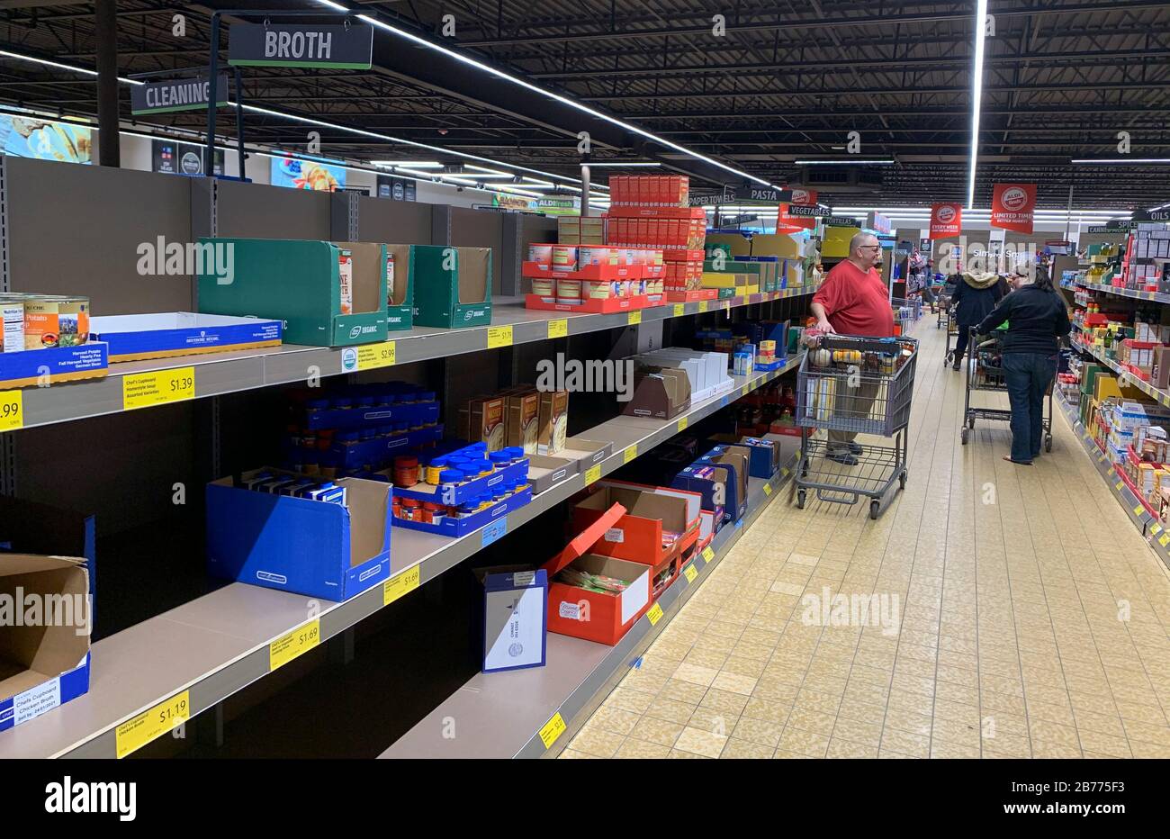 Bloomington, Stati Uniti. 13 Marzo 2020. Shoppers panico acquistare cibo in un negozio di alimentari Aldi a Bloomington.La donna sulla destra ha detto, 'ho tre bambini, ho devo fare quello che ho da fare.' il presidente degli Stati Uniti Donald J. Trump ha dichiarato un'emergenza nazionale solo ore prima. Credit: Sopa Images Limited/Alamy Live News Foto Stock