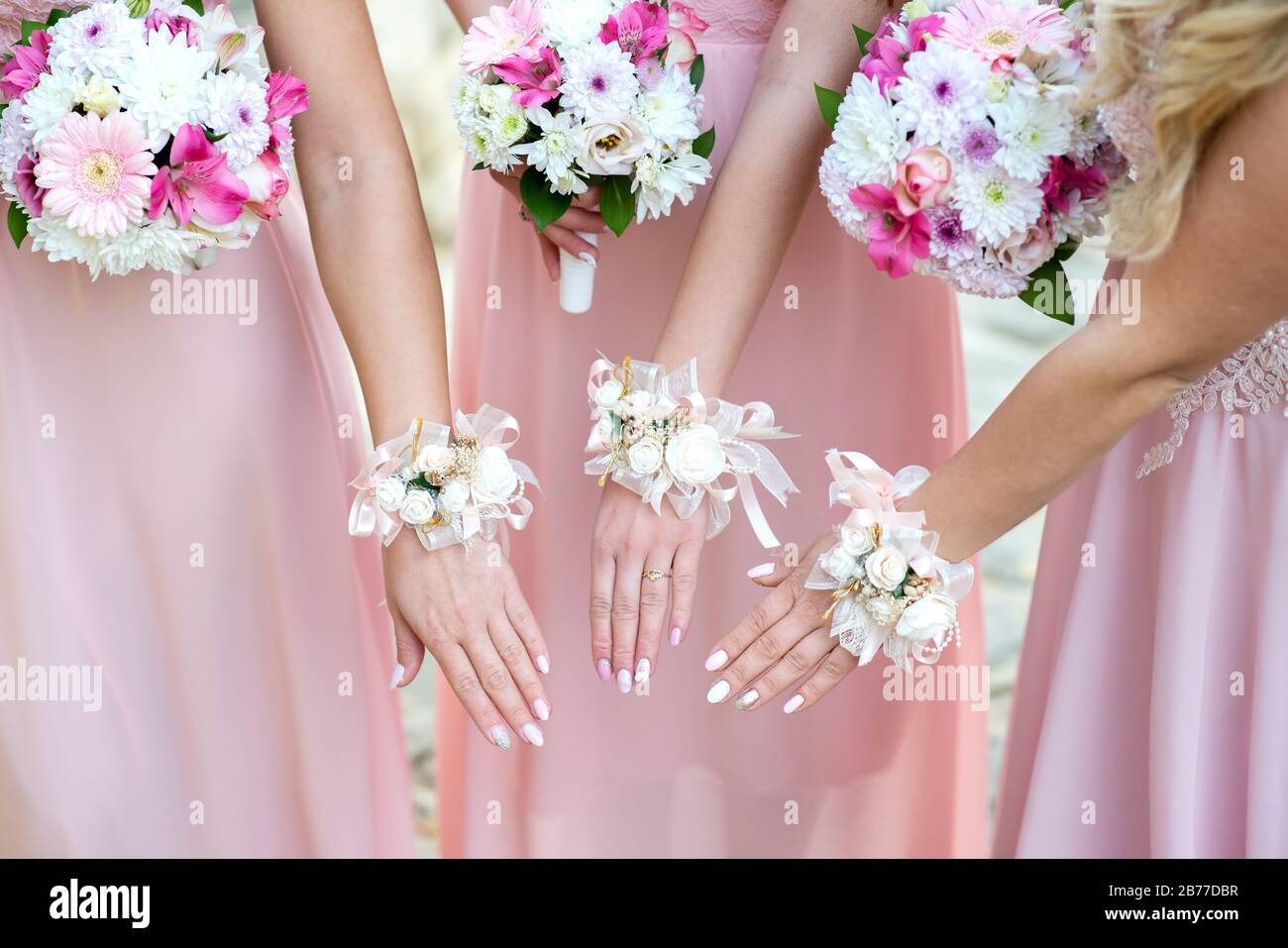 Glorious bridesmaids in abiti rosa che tengono bei fiori - fuoco selettivo Foto Stock