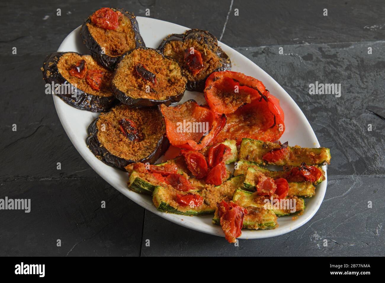 Miscela gratinata di verdure con fette di peperoni, melanzane e zucchine - shot studio orizzontale Foto Stock