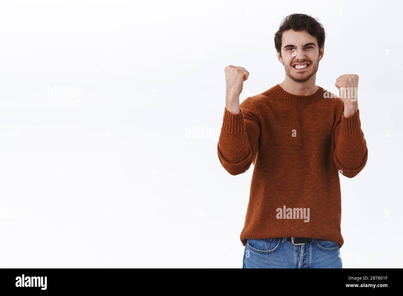 Sì, l'abbiamo fatto. Trionfando il giovane fortunato felice uomo vince il premio, il pugno pompa con gioia, celebrando le buone notizie, la vittoria e il concetto di successo, sorridendo soddisfatto Foto Stock