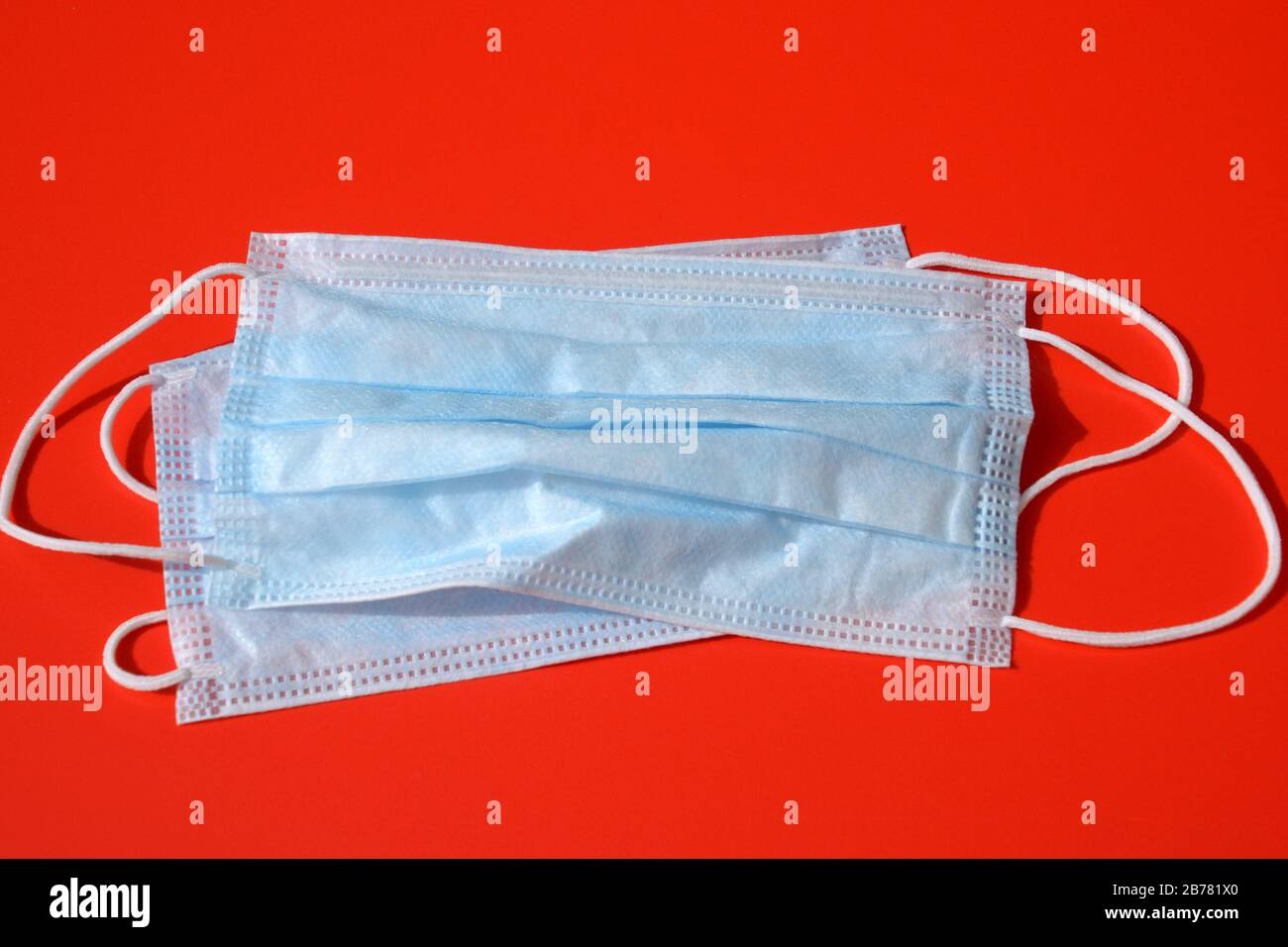 maschera medica con cuscinetti in gomma sul pavimento rosso come concetto di protezione, protezione antivirus con maschera clinica per bocca e naso Foto Stock