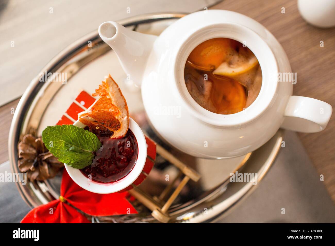 Tè marocchino con arancia e limone in una teiera con marmellata di lamponi e spezie Foto Stock