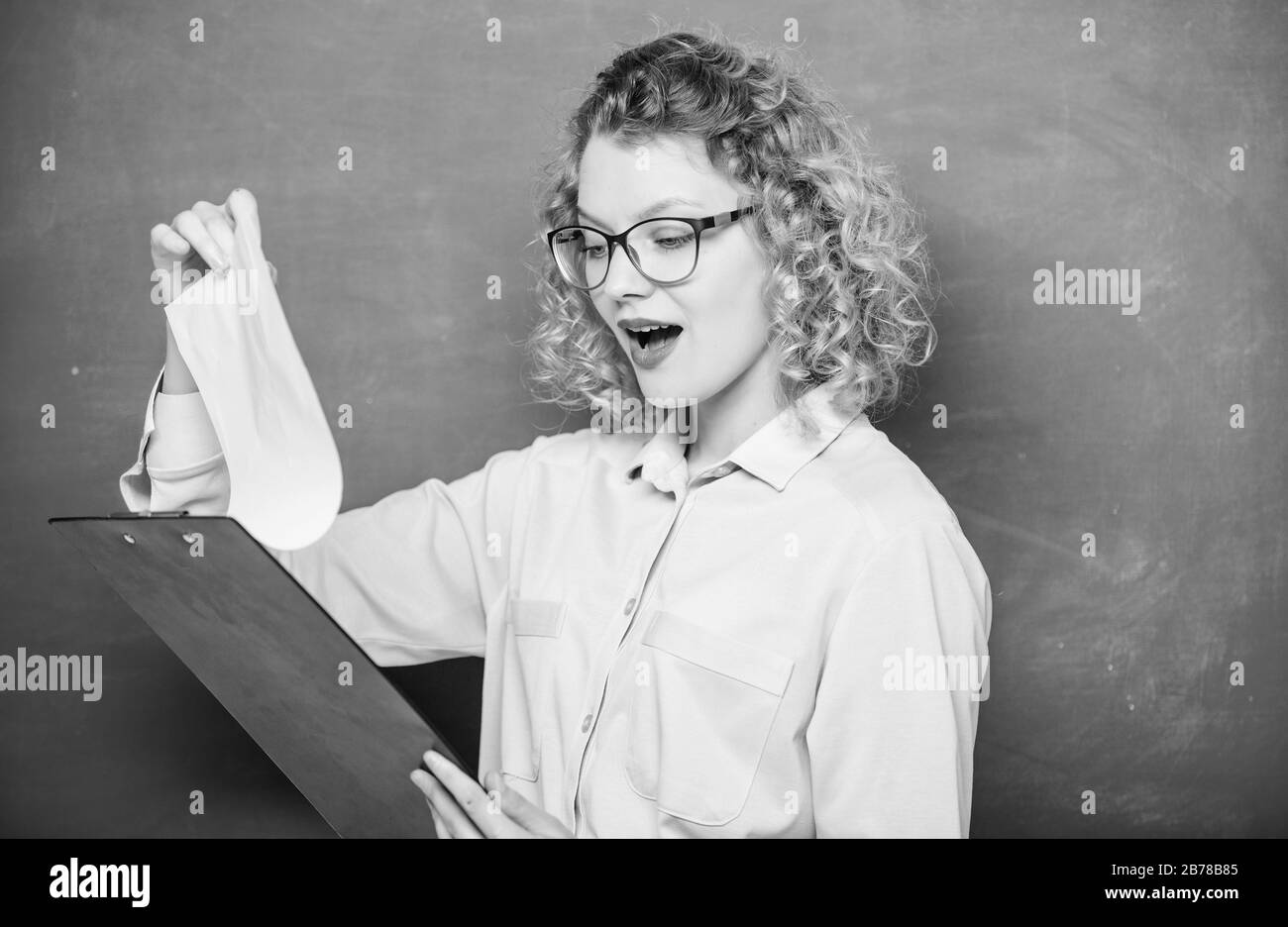 Progetto scuola. Insegnante di letteratura leggere composizione. Leggere impressionando riprendere. Il tutor compiti di controllo. Donna smart lady tenere documenti tablet. Leggere il profilo personale. Saggio di stima dei richiedenti. Foto Stock