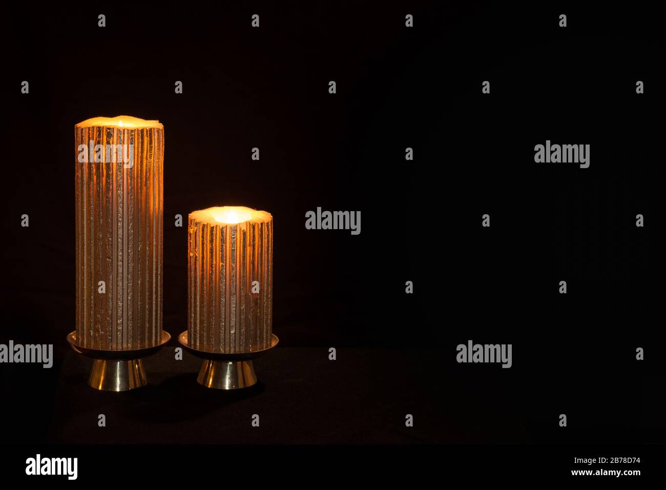 Due candele accese spinte a sinistra per consentire l'uso come backgroound o slide del titolo Foto Stock