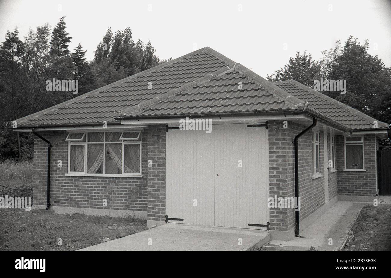 Fine degli anni '60, i primi anni '70 nuova casa a piano singolo, un bingalow, di recente costruzione, con integrale singolo garage, Inghilterra, Regno Unito. Foto Stock