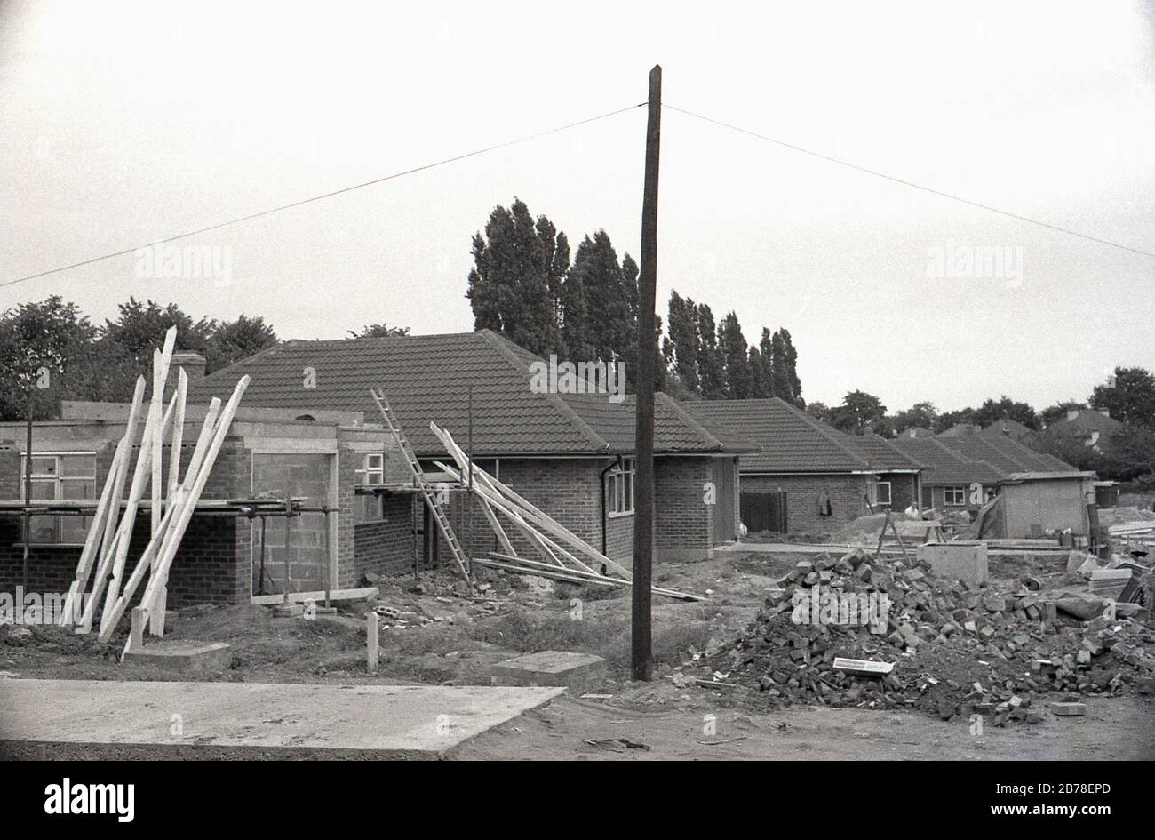 Verso la fine degli anni '60, forse all'inizio degli anni '70, uno sviluppo di nuove moderne abitazioni a piano singolo o bungalow in costruzione, Inghilterra, Regno Unito. Foto Stock