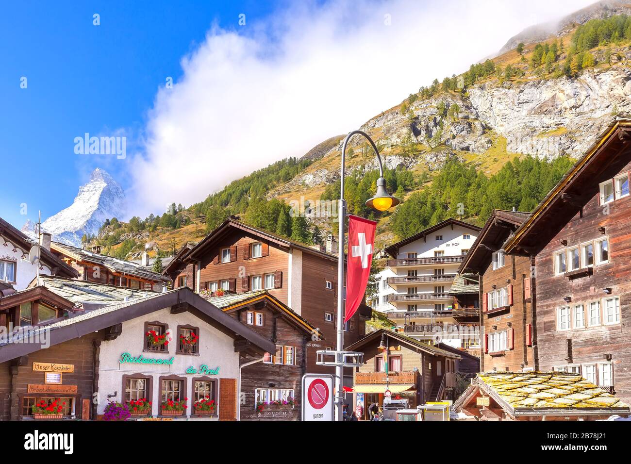 Zermatt, Svizzera - 7 ottobre 2019: Vista sulla strada della città nella famosa località sciistica svizzera, Monte neve Cervino, case tradizionali Foto Stock