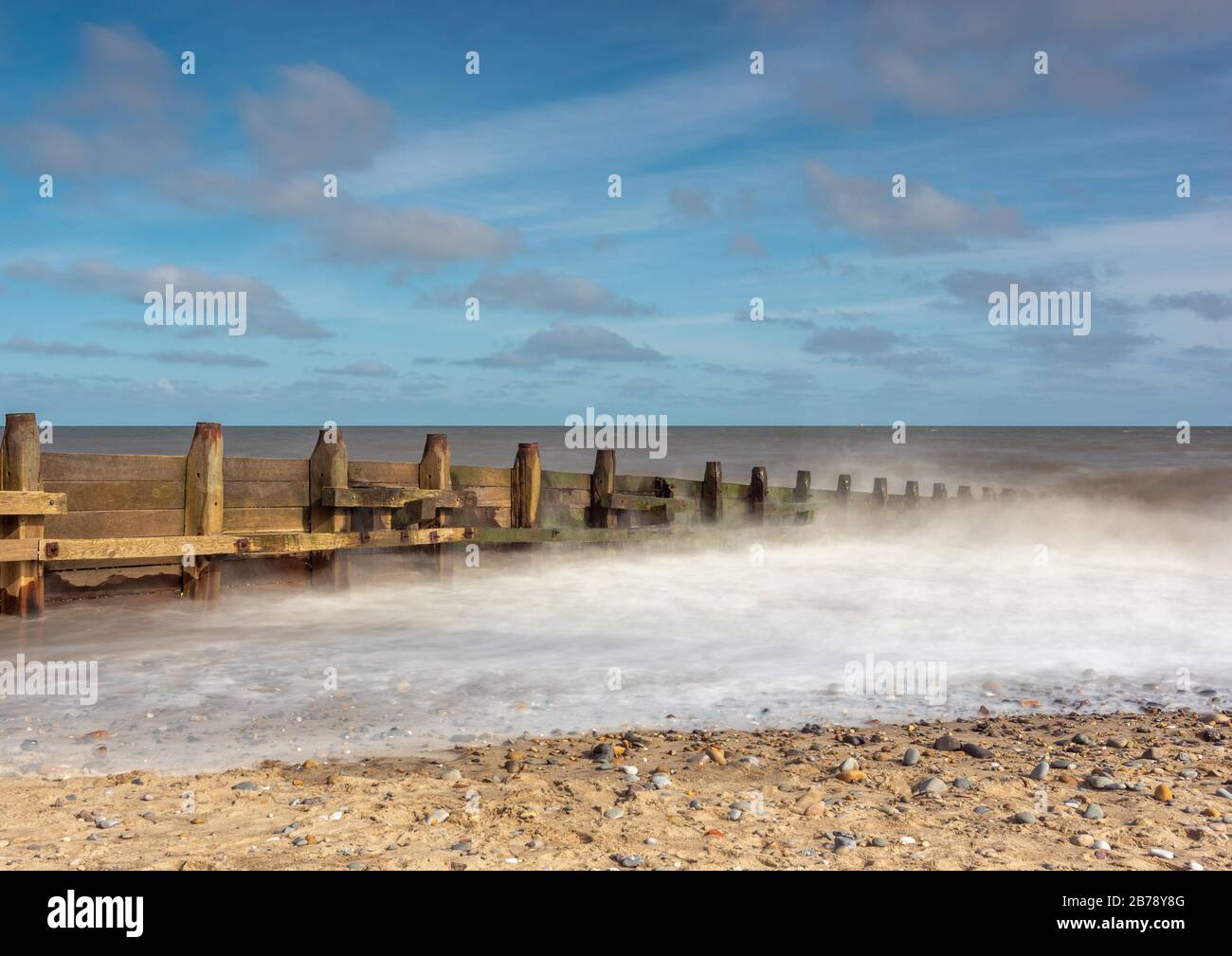 Le difese del mare di Groin con le onde di cricchiolatura Foto Stock