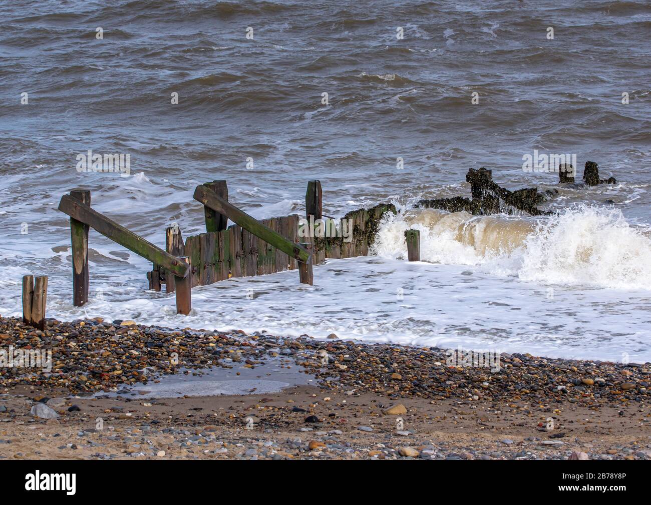 Le difese del mare di Groin con le onde di cricchiolatura Foto Stock