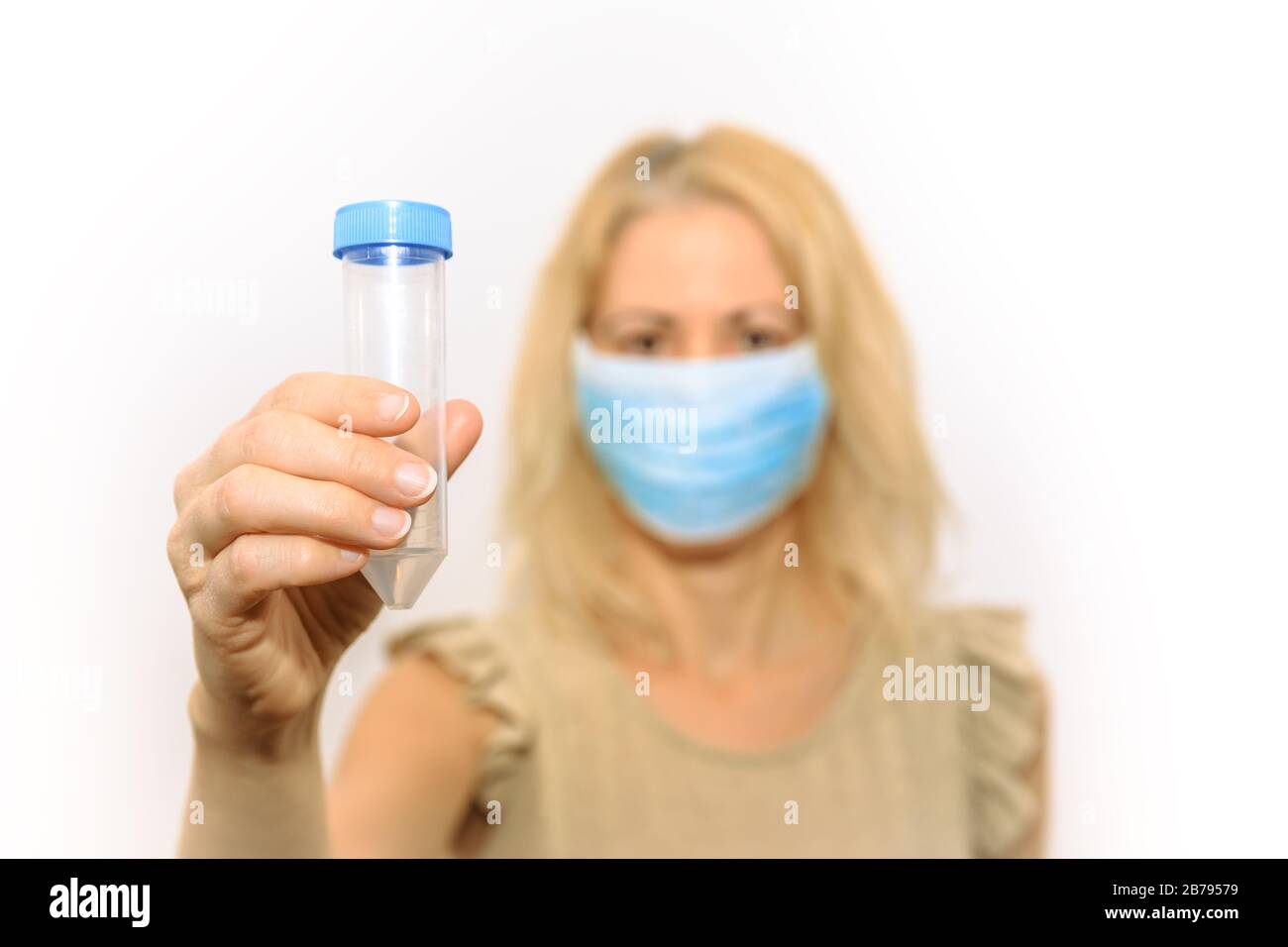 donna di ricerca bionda con maschera medica che contiene una provetta per test di laboratorio o esperimenti. Concetto di ricerca scientifica, test del virus Foto Stock