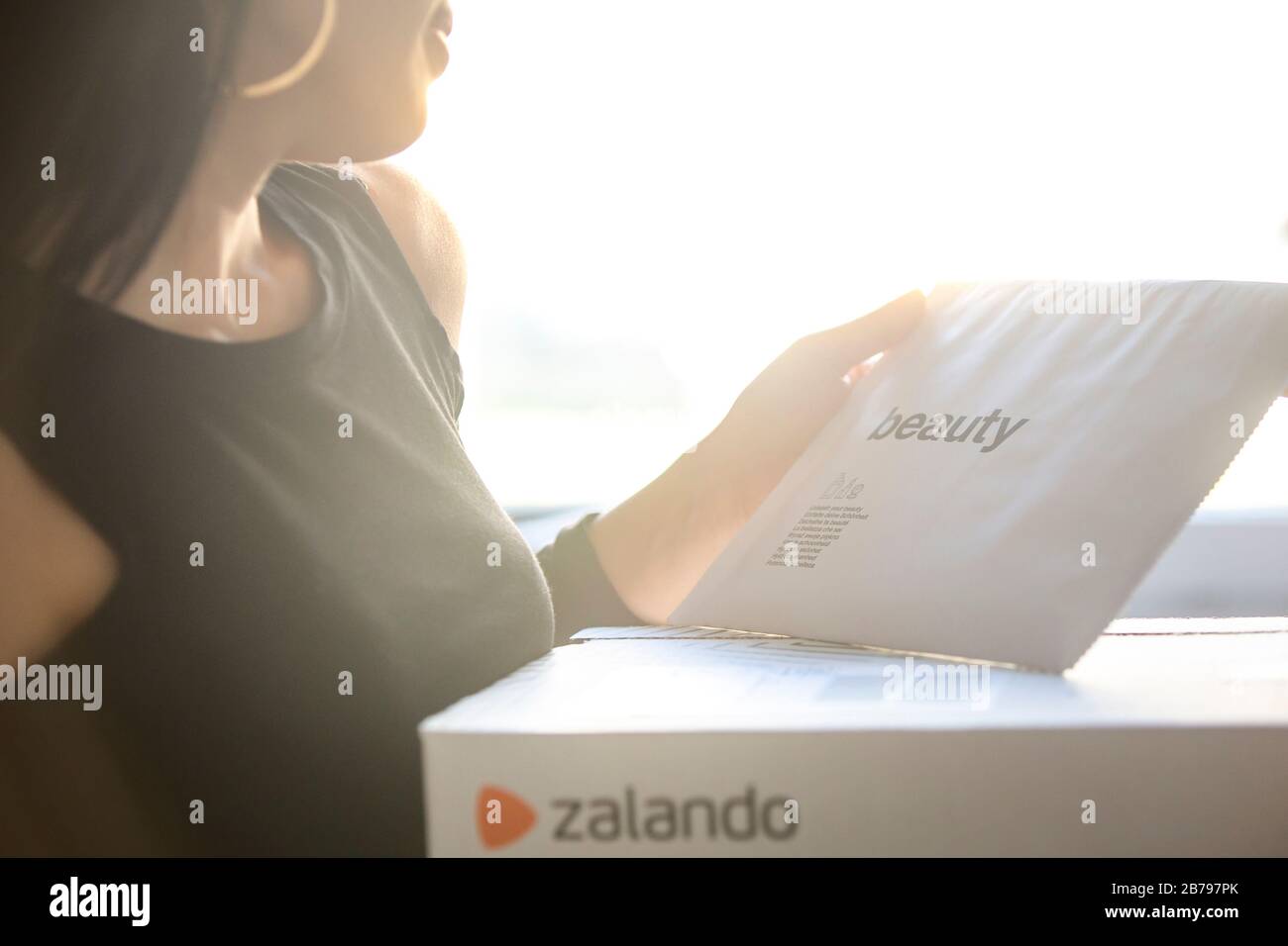 Poznan, Polonia - 14 marzo 2020: Donna in possesso di una scatola Zalando con gli articoli ordinati dal negozio online. Foto Stock