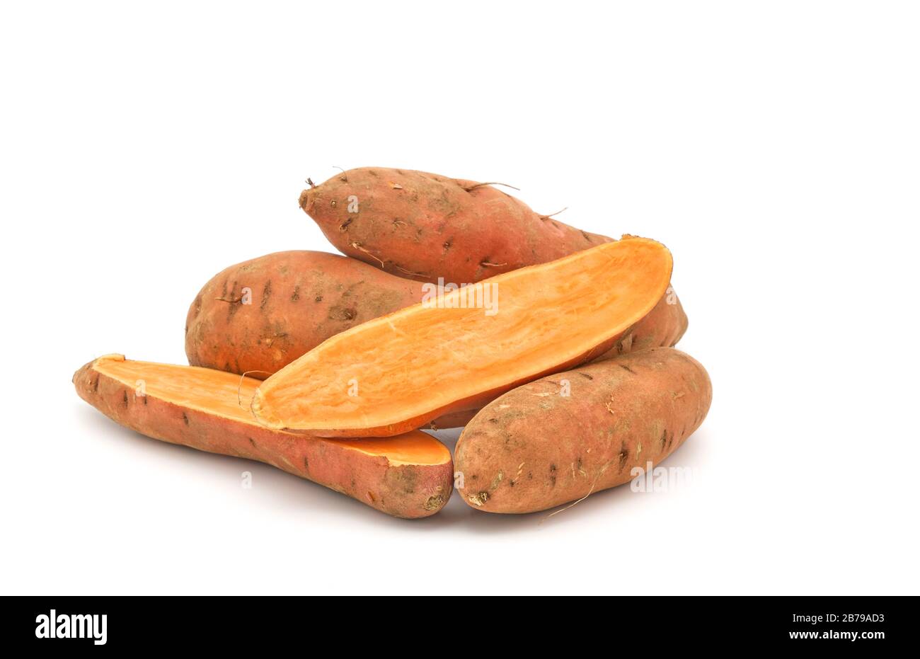 Patate dolci intere di arancia cruda, Ipomoea Batatas fotografato su sfondo bianco con ampio spazio per le copie. Foto Stock