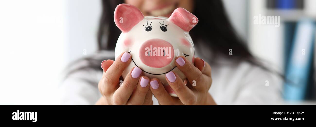 Donna sorridente con il salvadanaio Foto Stock