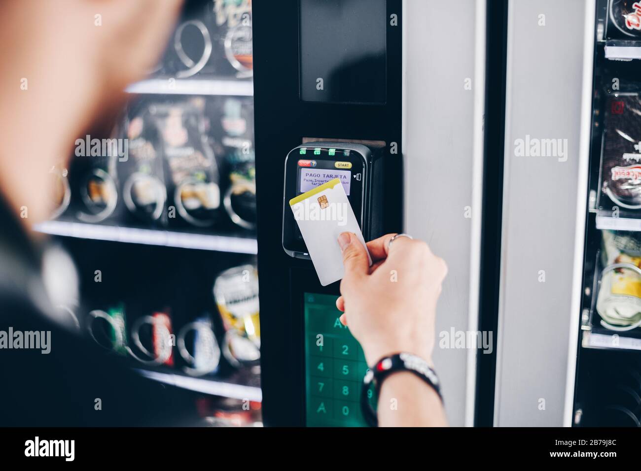 Studente che utilizza il metodo di pagamento senza contatto in un distributore automatico. Foto Stock