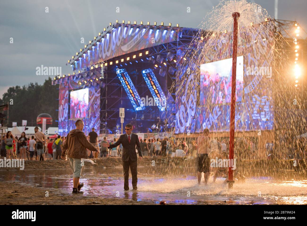 KOSTRZYN NAD ODRA, POLONIA - 3 AGOSTO 2017: Festival Przystanek Woodstock - ventilatori bagno nel fango di fronte al palco con riflessione sull'acqua. Foto Stock
