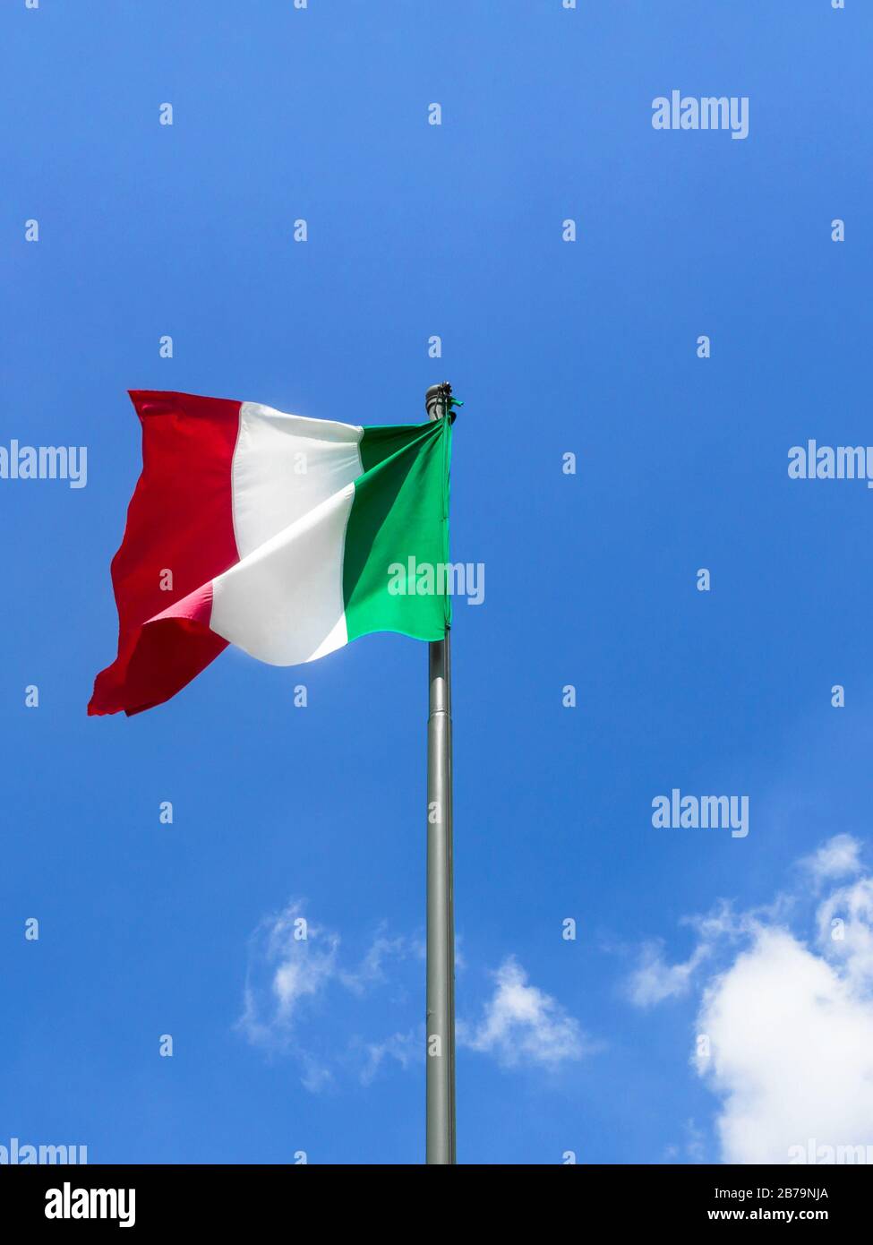 Sventolando la bandiera italiana contro il cielo blu. Bandiera italiana fluttering contro un cielo blu brillante. Spazio di copia. Foto Stock