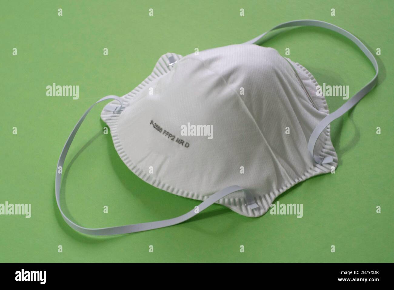 Maschera chirurgica con cinghie auricolari in gomma. FFFP2 sfondo verde Foto Stock