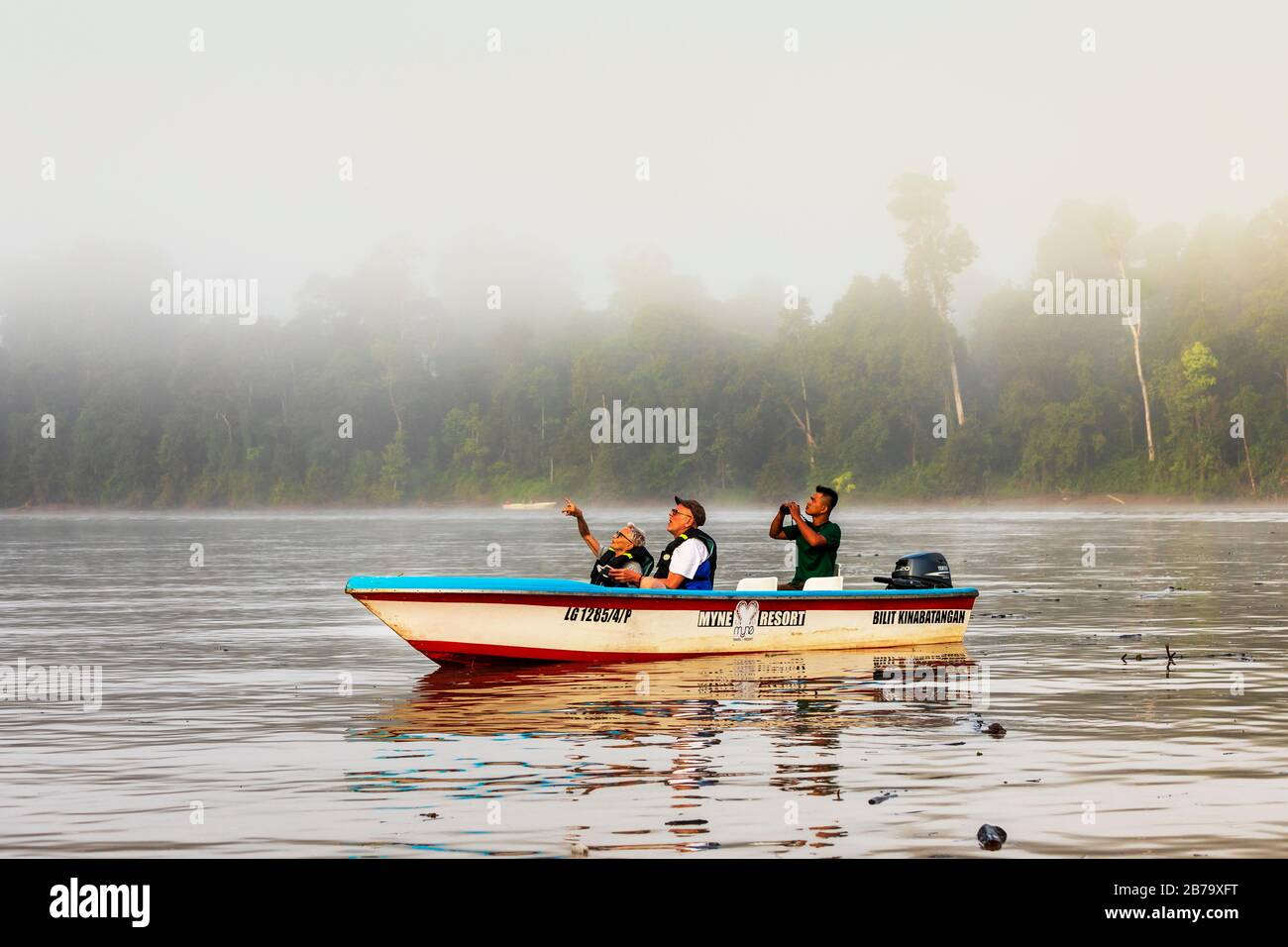 Turisti su una barca fluviale sul fiume Kinabatangan, Sabah distretto di Borneo su una fauna selvatica guardare nella foresta pluviale, Sabah, Borneo, Malesia, Asia Foto Stock