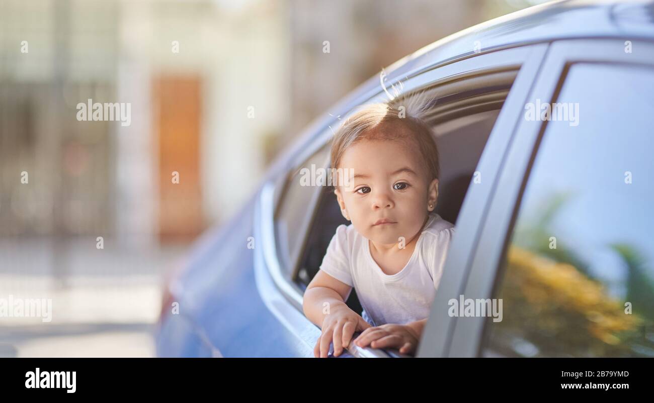 Una bambina viaggia in auto e guardando fuori dalla finestra Foto Stock