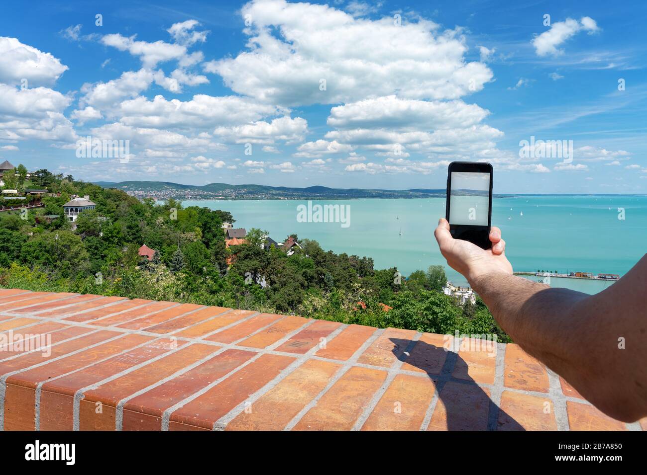 Tourist scattare foto con il suo telefono da Tihany abbazia su una delle più belle vista del lago Balaton Foto Stock