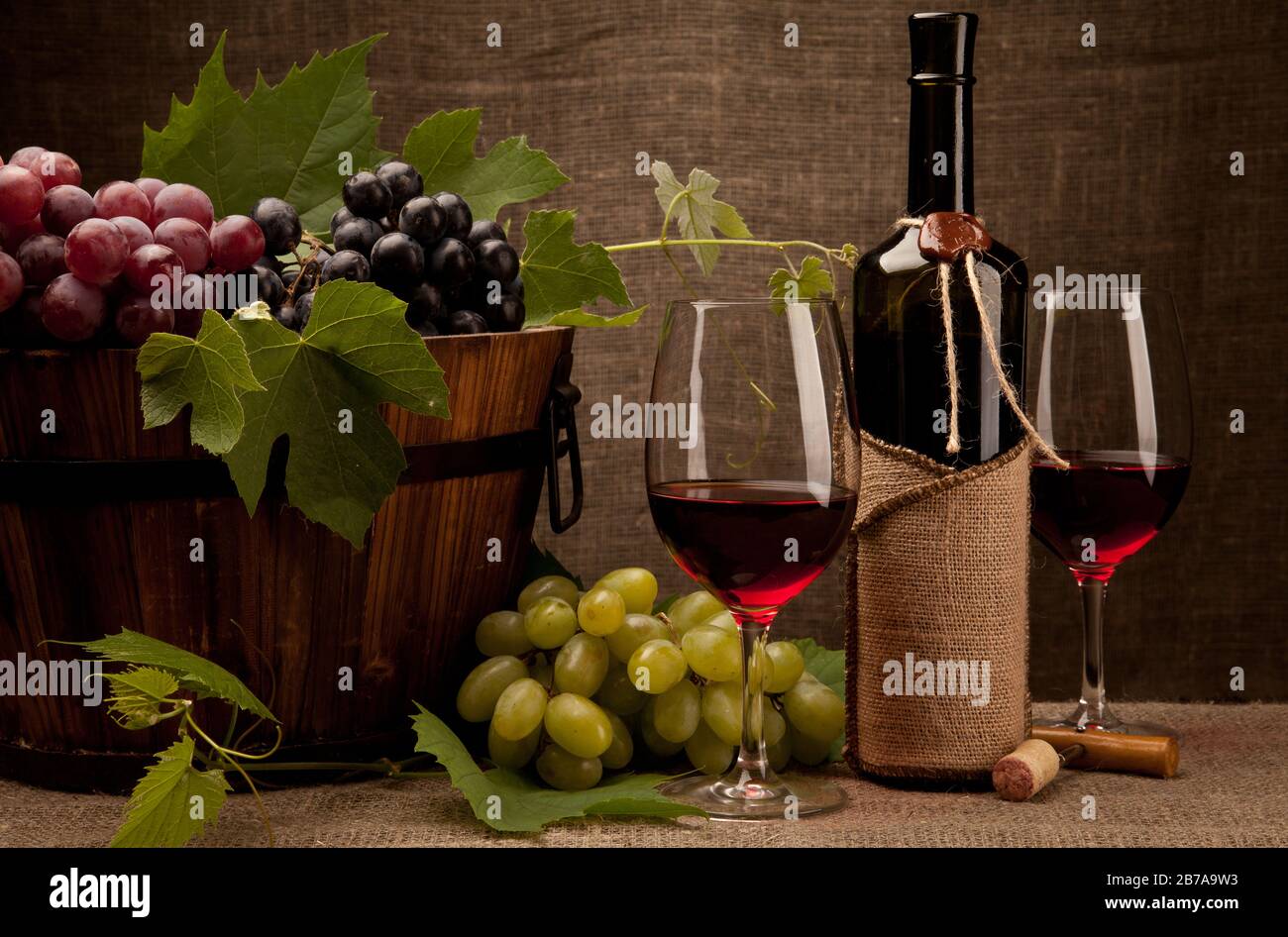 Ancora vita con bottiglie di vino, bicchieri e uva Foto Stock