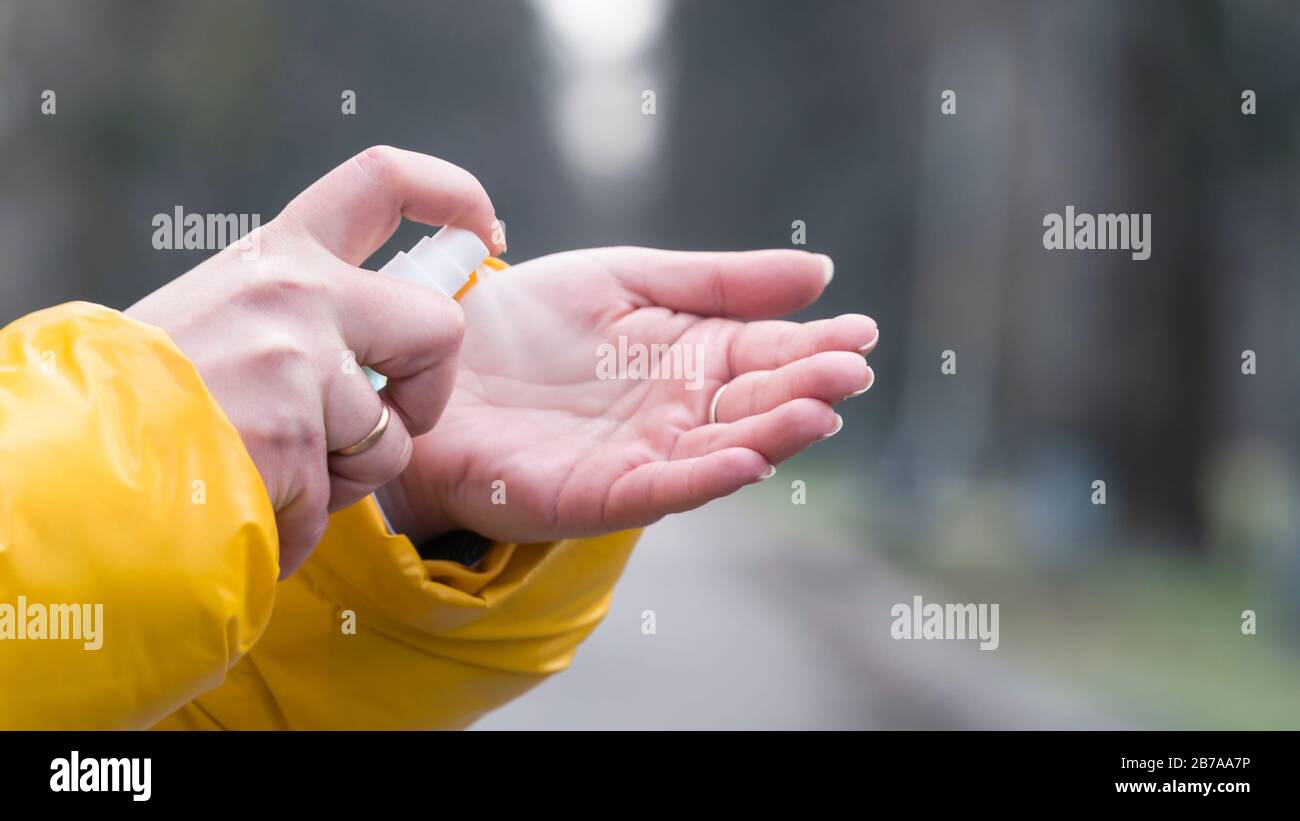 Primo piano della mano femminile con spray antisettico o antibatterico. Disinfezione delle mani. Concetto di assistenza sanitaria durante un'epidemia o pandemica Foto Stock