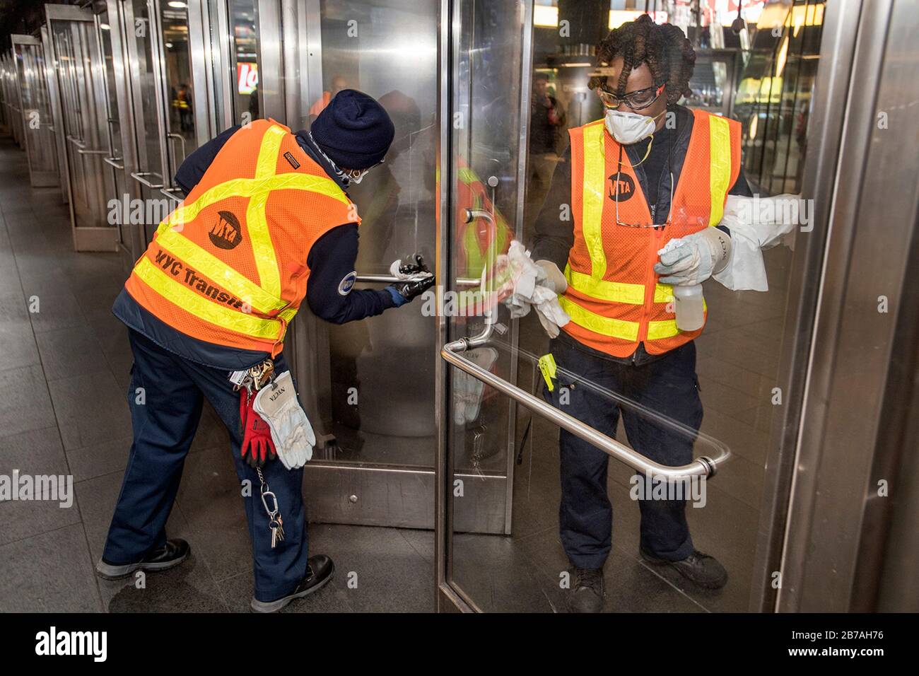 I lavoratori della Metropolitan Transportation Authority disinfettano e sanitizzano le maniglie delle porte per prevenire il COVID-19, coronavirus nel sistema della metropolitana di New York City Transit 12 marzo 2020 a New York City, New York. Foto Stock