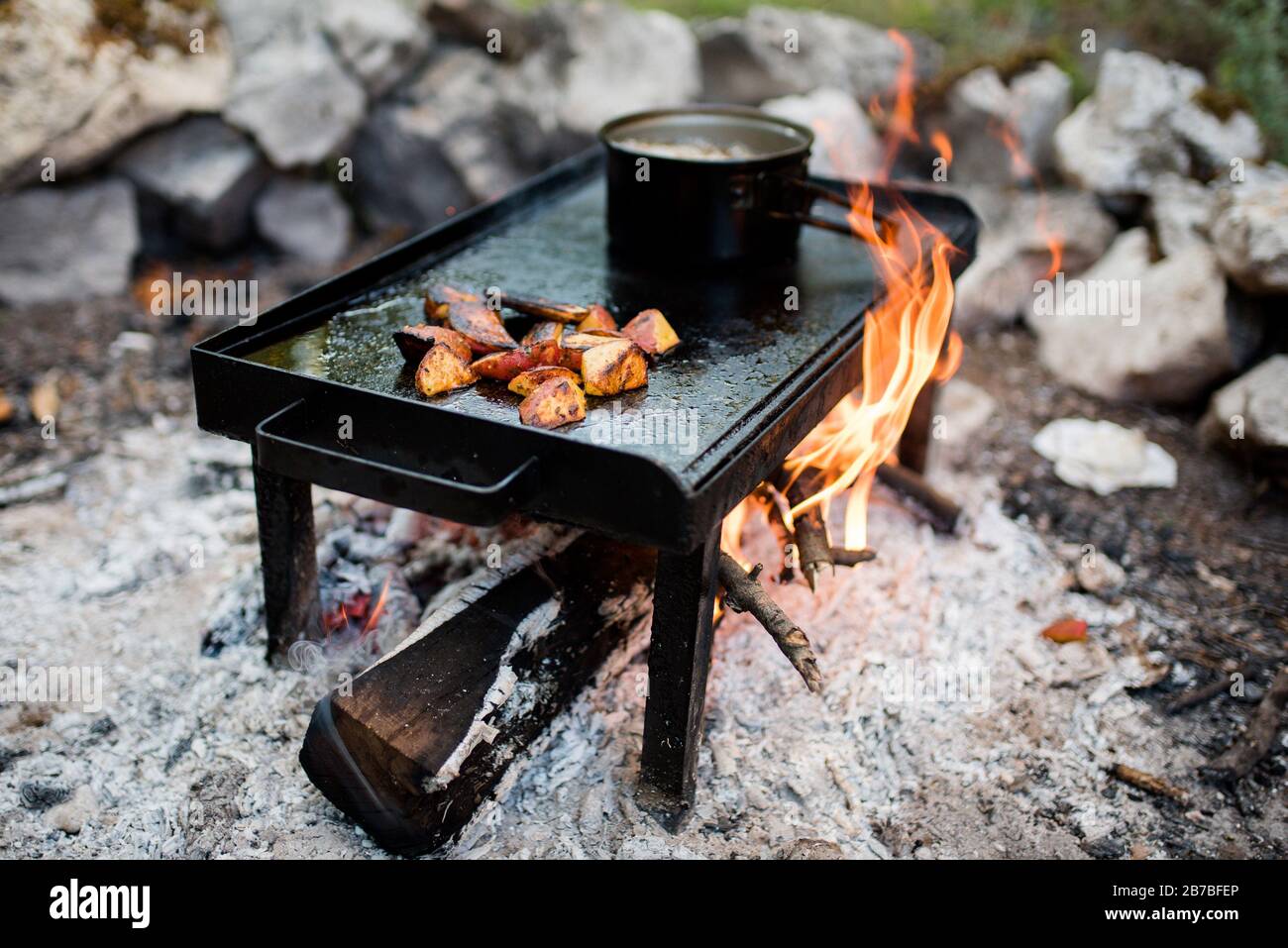 Patate arrosto alla griglia su pietra barbecue caldo Foto Stock