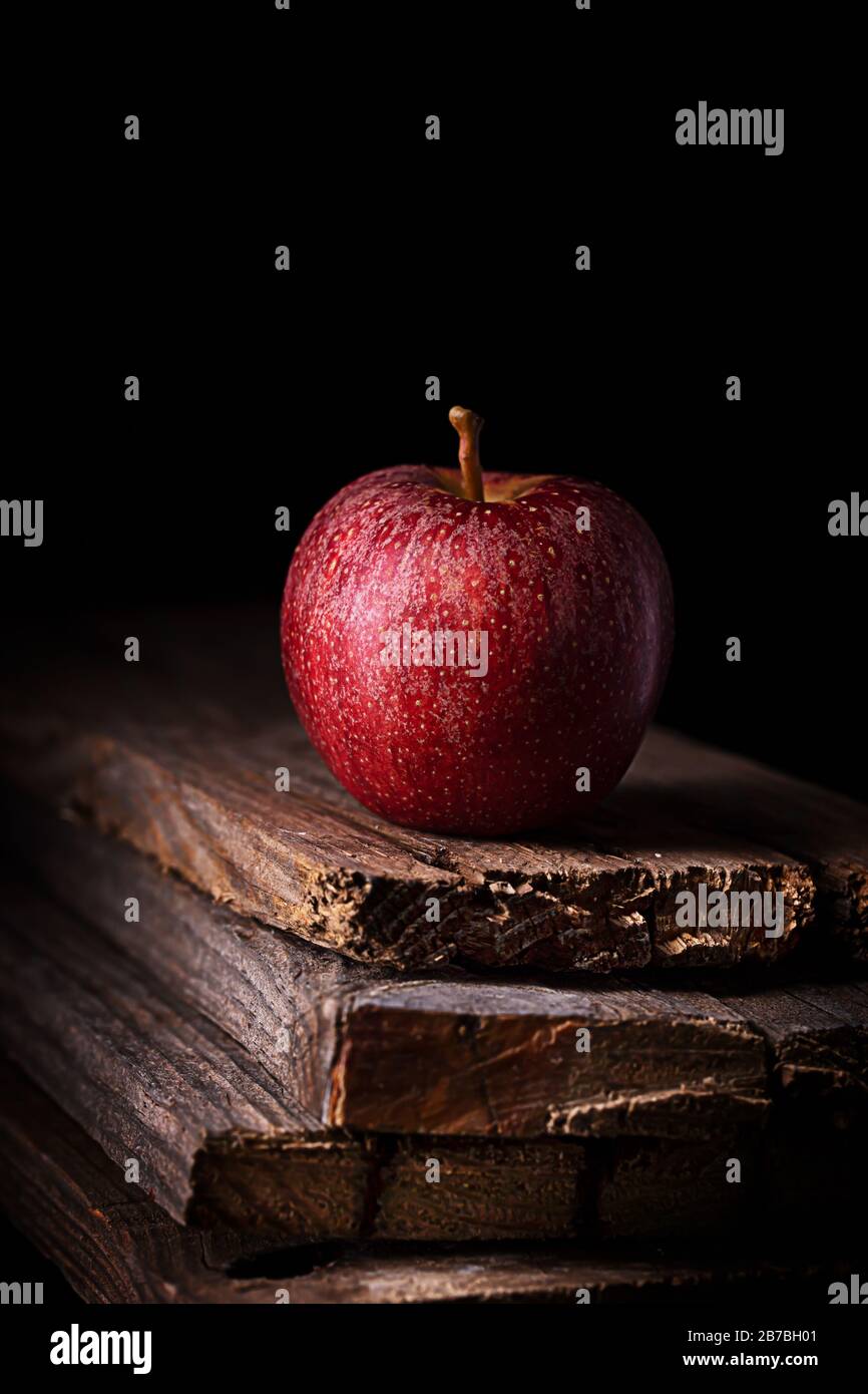 Una mela rossa su sfondo nero, orientamento verticale Foto Stock