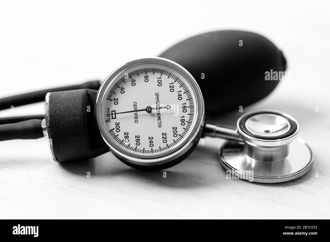 Pressione sanguigna - uno sfigmomanometro (uno strumento per la misurazione della pressione sanguigna) su un desktop di legno bianco. Foto Stock