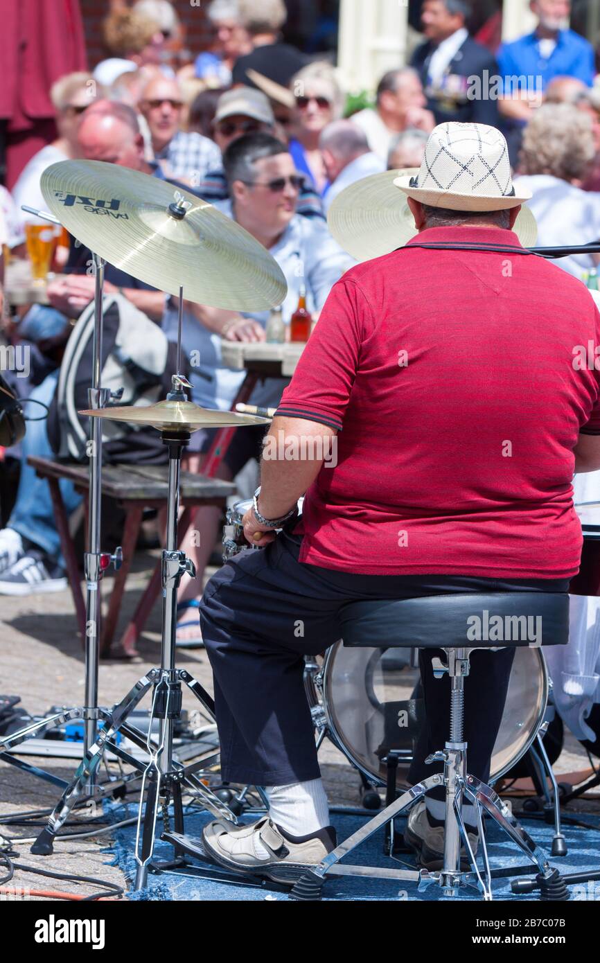 Un uomo che suona la batteria in un festival di musica all'aperto a Brewers Square, Weymouth, Dorset. Foto Stock