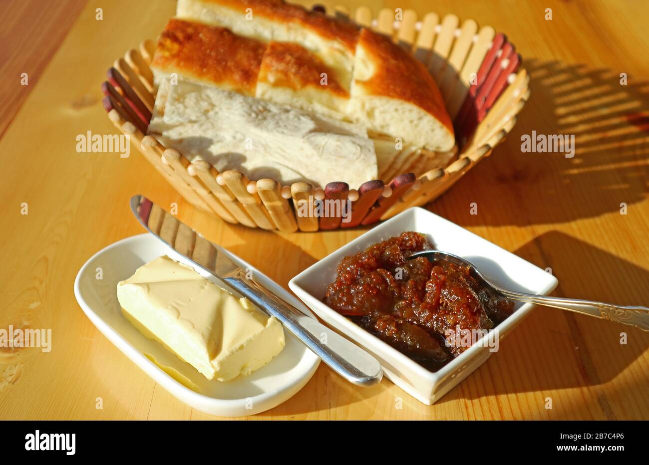 Marmellata di fichi e burro fatti in casa con cesto di pane armeno sfocato sullo sfondo Foto Stock