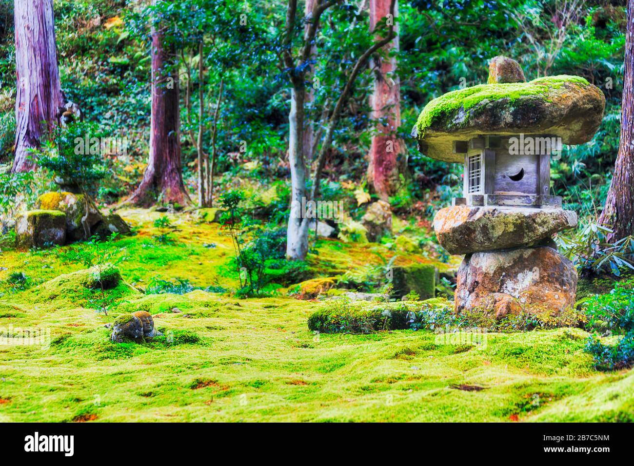 Prato verde di muschio e fungo nel tradizionale giardino ornamentale giapponese nel villaggio di Ohara vicino a Kyoto. Piccole figurine di pietra e capanna di alveare sulla erba Foto Stock