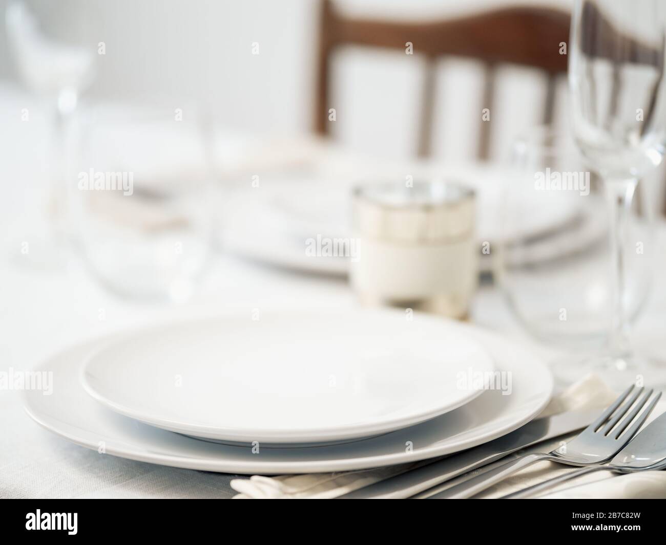 Bella tavola in bianco. Piastre bianche vuote. Tavolo fisso per cena romantica per due a casa Foto Stock