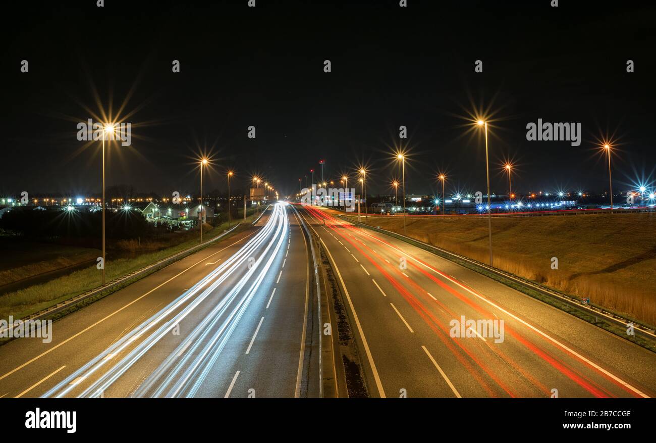 Piste per auto leggere sull'autostrada A12 nei Paesi Bassi di notte. L'uscita 10 con il nome di luogo 'Moordrecht' dopo 1700 metri è scritto su un tabellone. Foto Stock