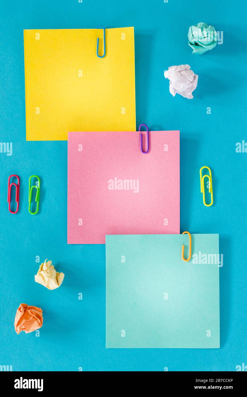 Carte colorate con spazio per un'iscrizione, ufficio o concetto di business, punti metallici, palle di carta sbriciolate. Foto Stock